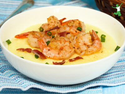 grain free shrimp and grits in white bowl on blue tablecloth