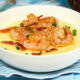 grain free shrimp and grits in white bowl on blue tablecloth