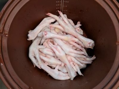 Chicken feet in a clay pot for soup or broth