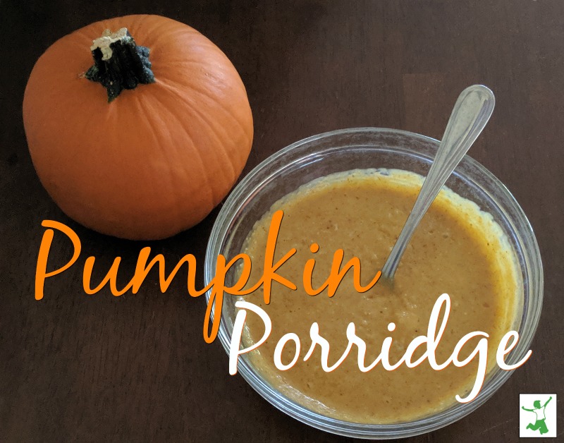 Pumpkin spice oatmeal in a glass bowl with spoon on wooden background