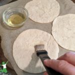 tortillas on a cookie sheet basted with oil