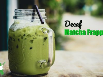 decaf matcha frappe in a mason jar mug with a straw on a wooden table