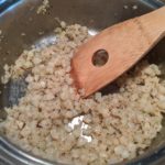 cooking cauliflower rice in butter in a pan