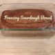 loaf of sourdough in a glass pan on a breadboard