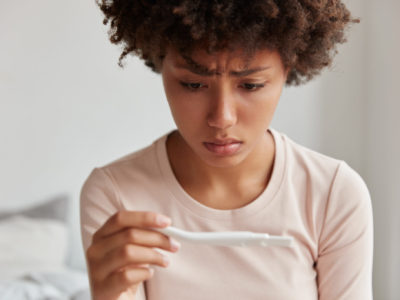 infertile woman staring at a pregnancy test result