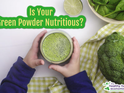 child holding green vegetable powder in a glass