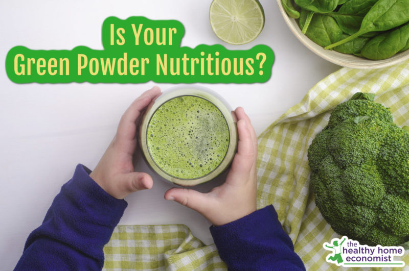 child holding green vegetable powder in a glass