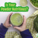 child holding green vegetable powder in a glass