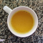 turmeric latte in a white mug on granite counter