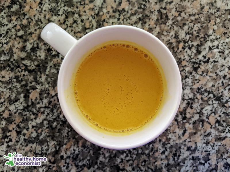 turmeric latte in a white mug on granite counter