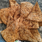 basted taco seasoning on tortilla chips in a glass bowl