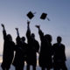 group of college graduates tossing their caps