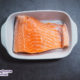 salmon fillet in a white baking dish