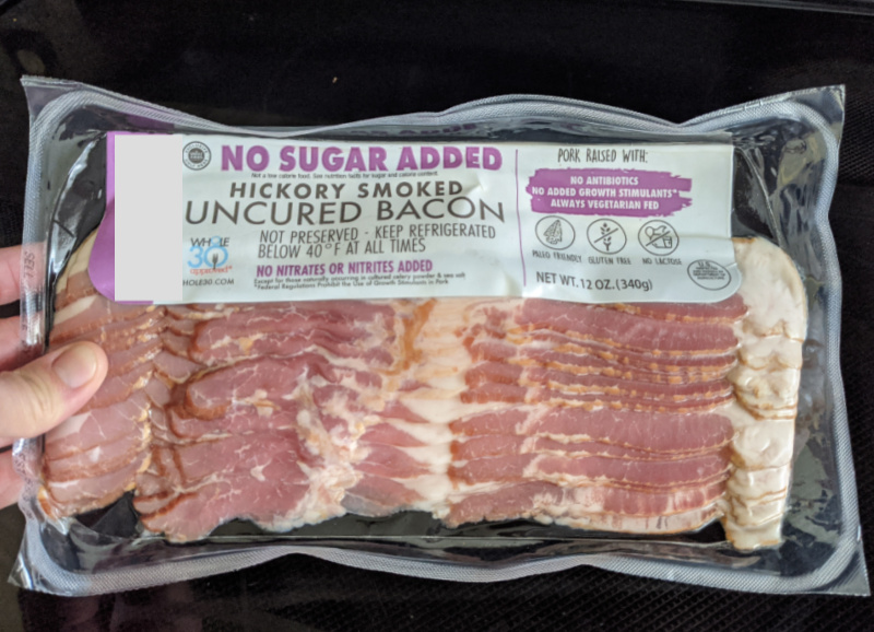 woman holding a package of sugar-free bacon