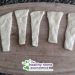 triangles of crescent roll dough on a cutting board