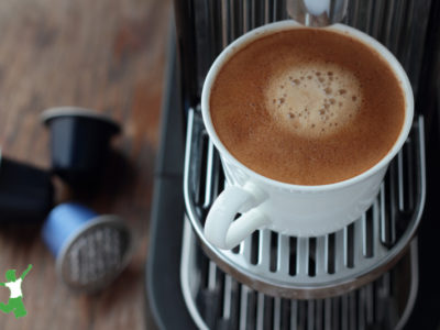 compostable coffee pods on a counter next to a single-use machine