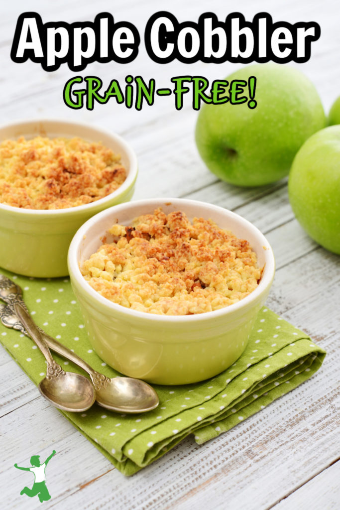 paleo apple cobbler in bowls on wooden table with green apples