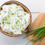 DIY pasteurized cream cheese in a bowl with rosemary
