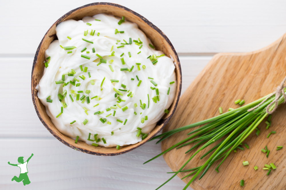 DIY pasteurized cream cheese in a bowl with rosemary