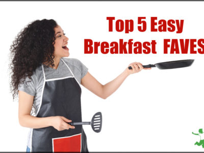 woman in apron with a fry pan and spatula making breakfast