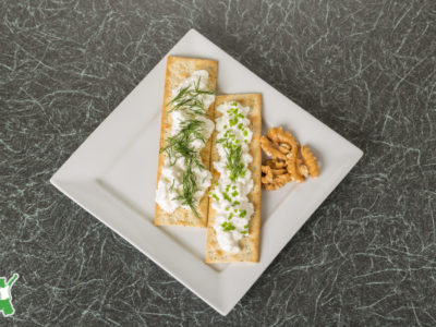 gluten free herbed crackers on a white plate with dip