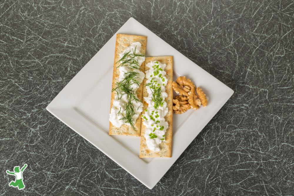 gluten free sprouted crackers on a white plate with herbed dip