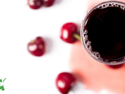 beneficial tart cherries and glass of juice on a white background