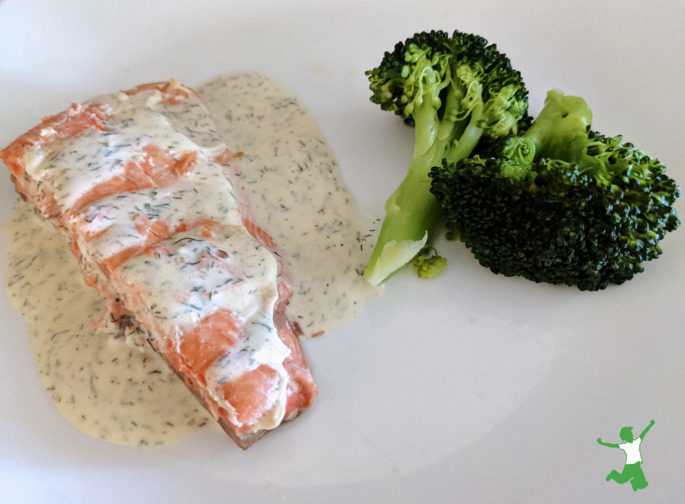 salsa casera de eneldo saludable sobre salmón con llovizna de brócoli