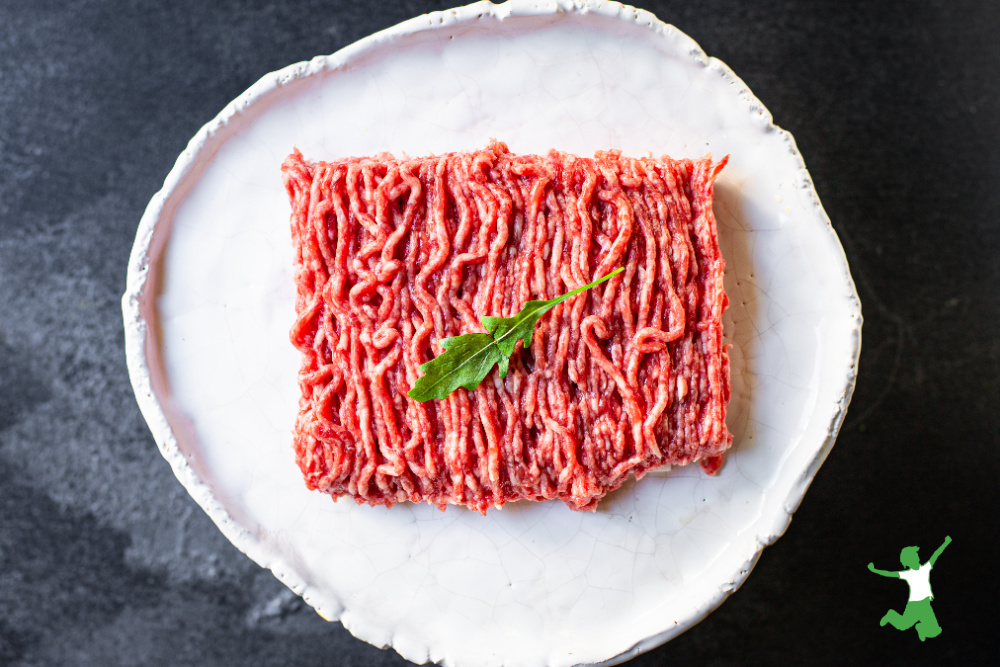 pound of ground pork marinating on a white plate