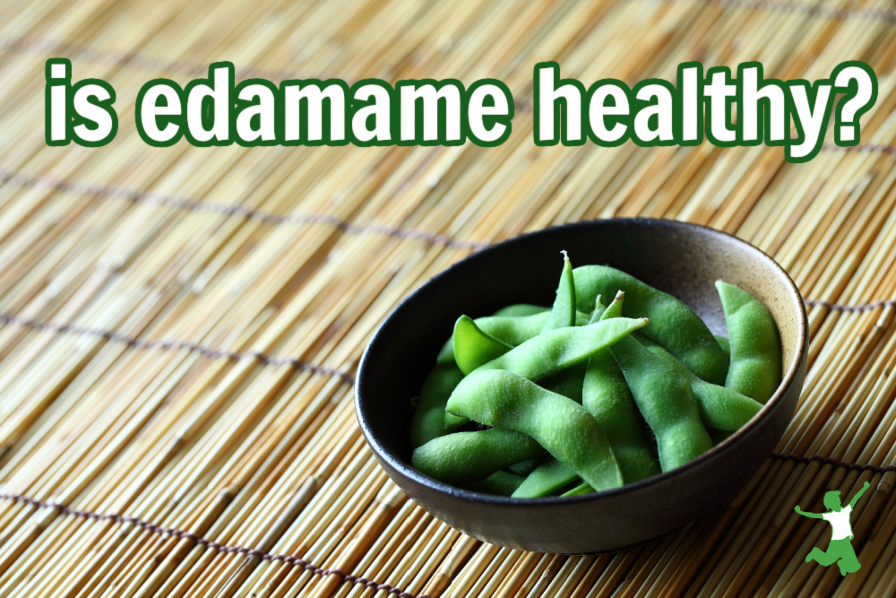 boiled edamame pods in a bowl on a bamboo mat