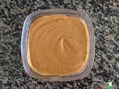 peanut satay sauce in a small glass bowl on granite counter