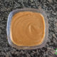 peanut satay sauce in a small glass bowl on granite counter