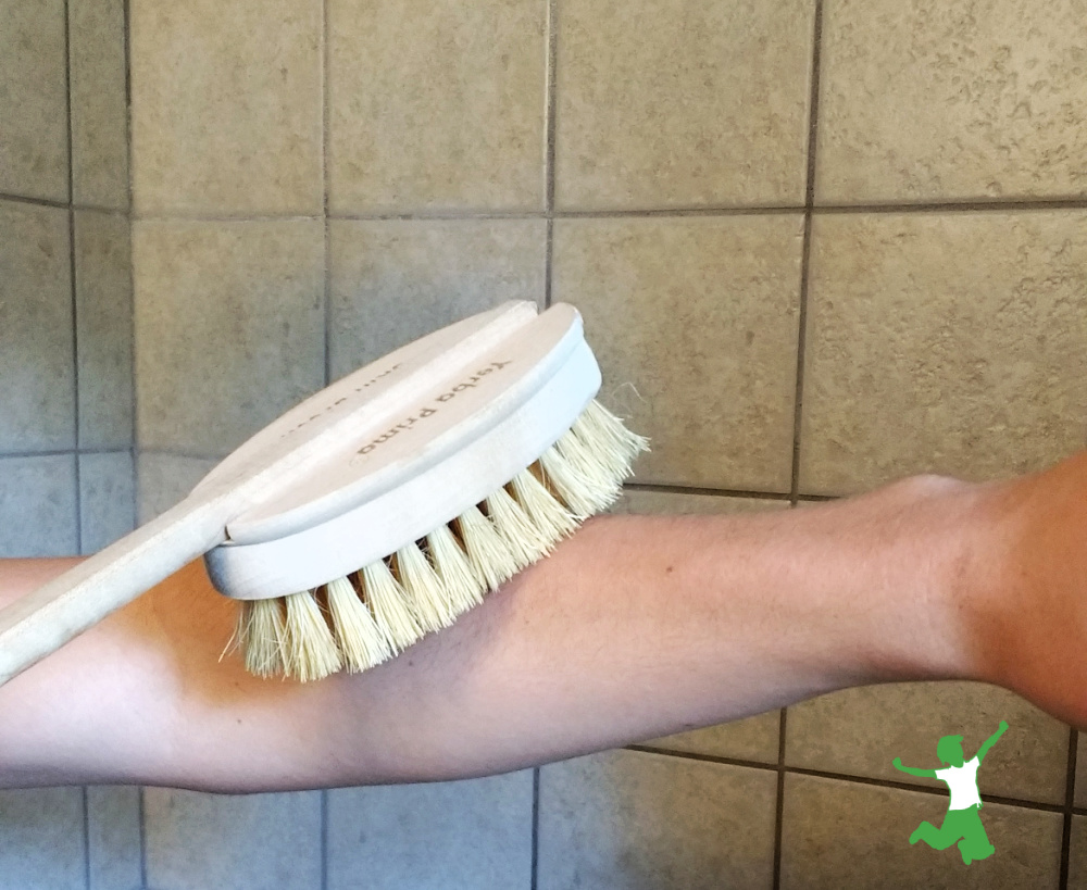 young woman dry skin brushing in shower