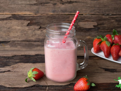 coconut milk strawberry banana smoothie in a mason jar with straw