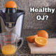 healthy oj with a juicer and sliced oranges on countertop