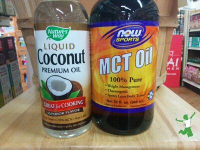 bottles of liquid coconut oil and mct oil on wooden table