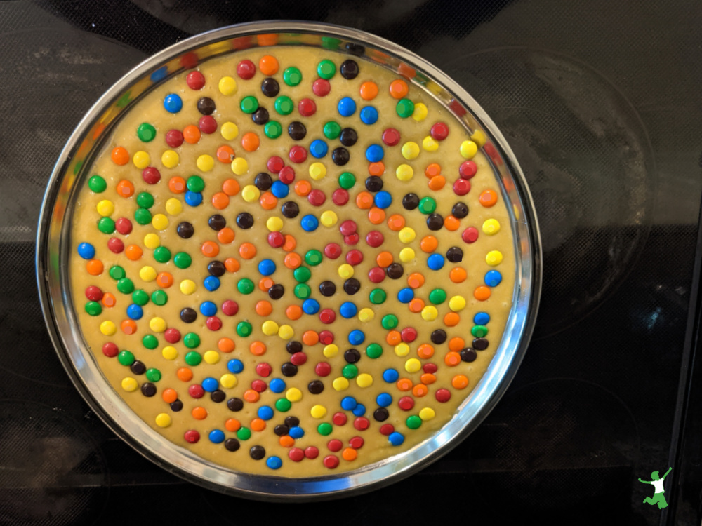 healthy m&m cookie cake in a stainless steel pan