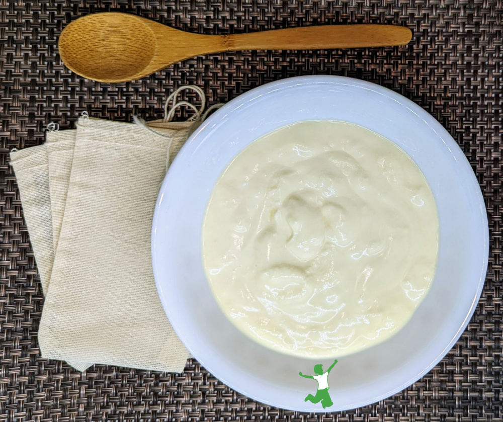 live kefir grains in a bowl with cotton bags and wooden spoon