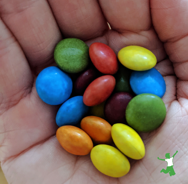 naturally colored rainbow chocolate candies in a woman's hand