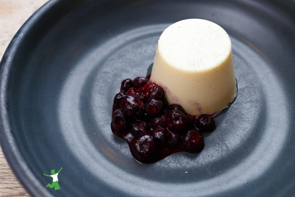 creamy and healthy panna cotta with berries on a metal plate