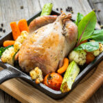 roast pheasant with vegetables on wood cutting board