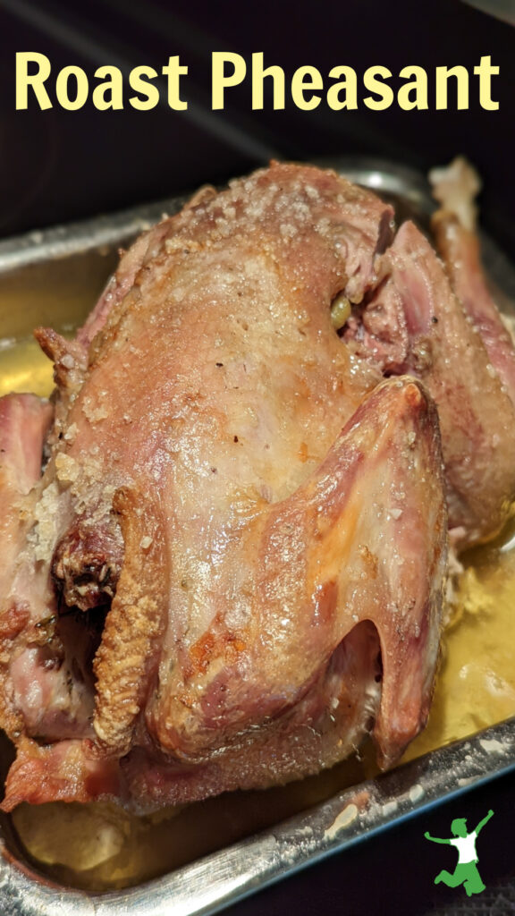 roast pheasant in baking pan with basted butter and garlic