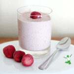 glass of vanilla ice cream strawberry jello pudding on white plate