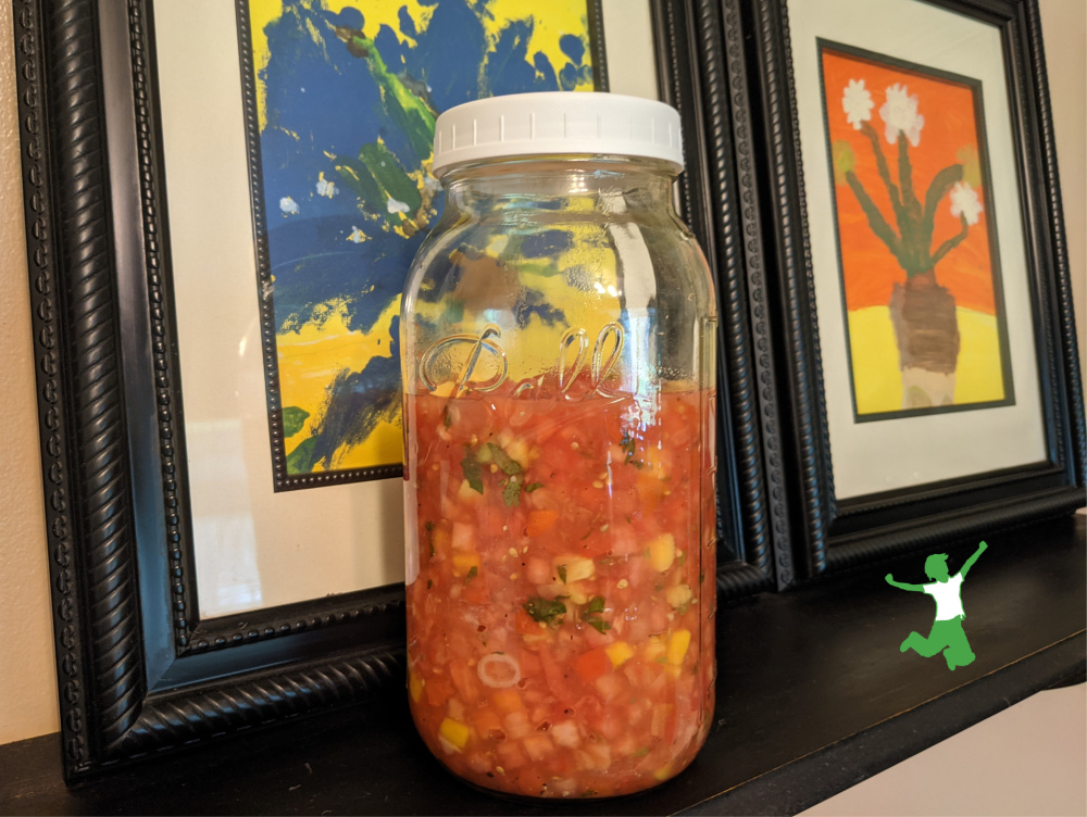 5 minute fermented salsa in mason jar on black shelf with colorful background