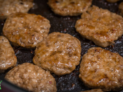 homemade sausage patties cooking in a pan