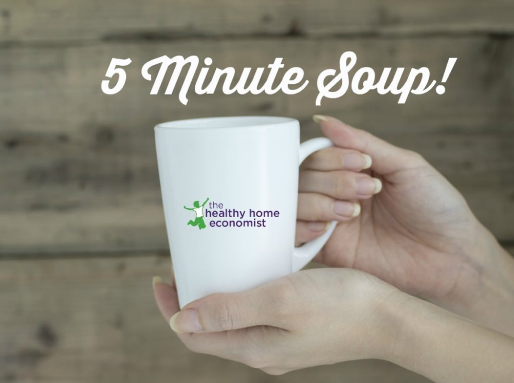 woman holding a white mug of soup made in five minutes