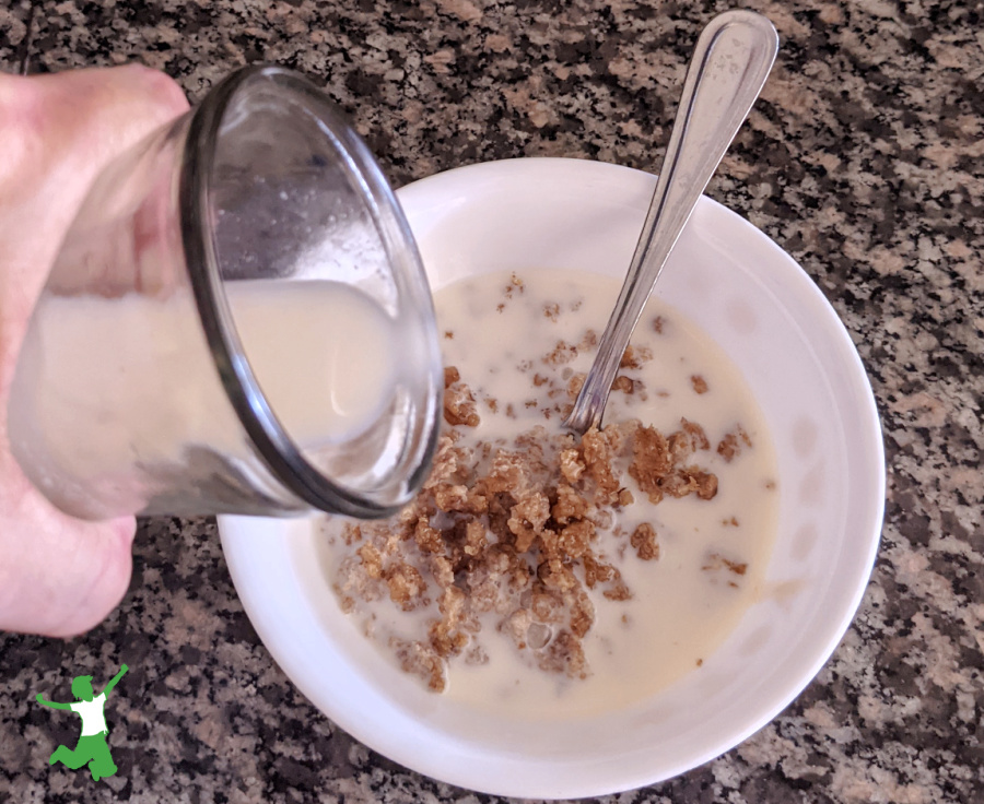 homemade oats and honey breakfast cereal in white bowl with milk