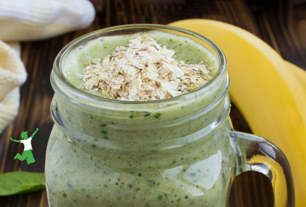 raw oats on top of a fruit smoothie in glass mug