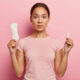 woman holding toxic tampon and pad