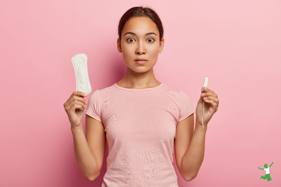 woman holding toxic tampon and pad with pink background